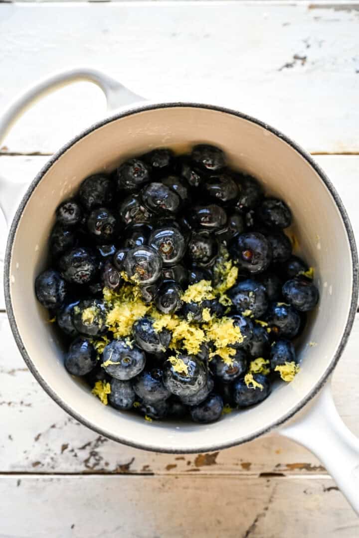 blueberry filling ingredients in white saucepan before cooking down.