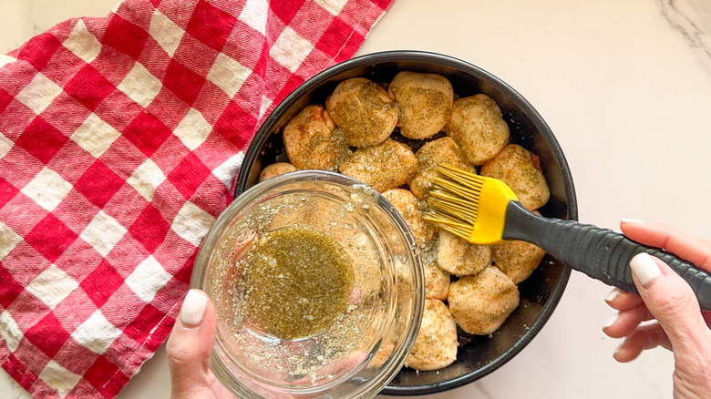 hand brushing oil mixture on bites