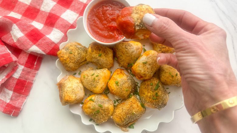 hand dipping bite in sauce