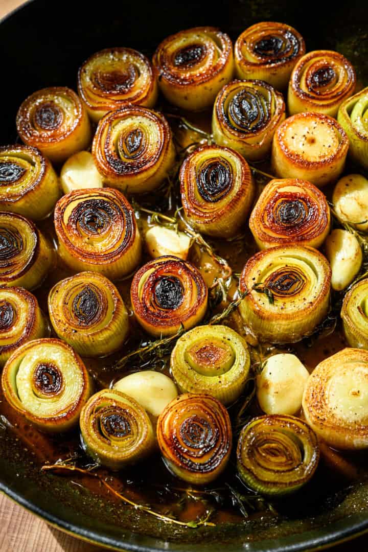 Overhead view of cooked leeks in a pan.