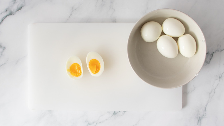 jammy egg sliced in half on cutting board