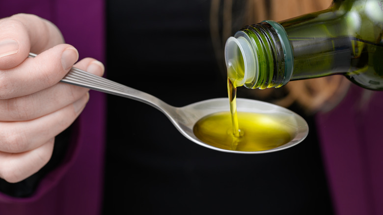 Pouring olive oil onto a spoon