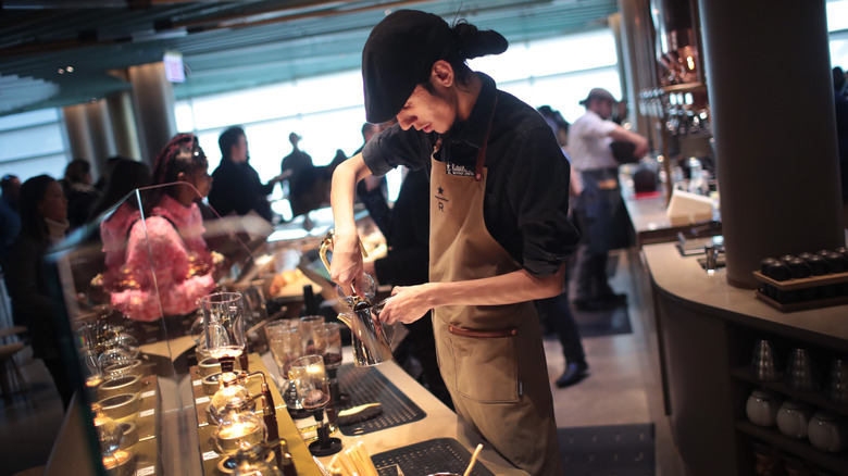 Starbucks barista working at the experiential Starbucks Reserve coffee bar ready to give someone a new experience in coffee