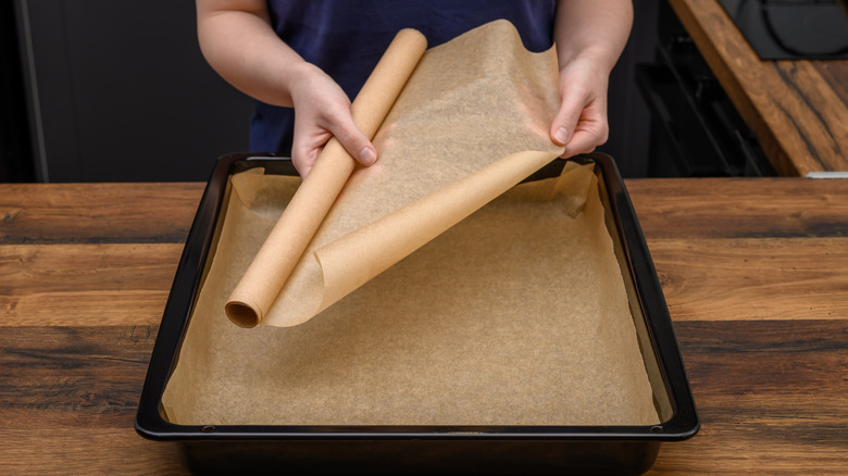 woman lining a baking sheet with wax paper