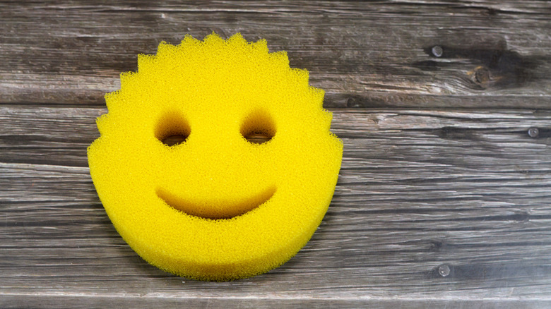 A yellow Scrub Daddy sponge on a wooden table.