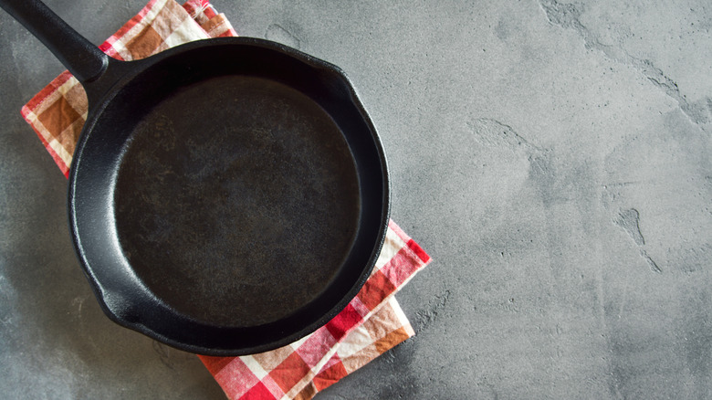 A cast iron pan on a cloth with a gingham pattern
