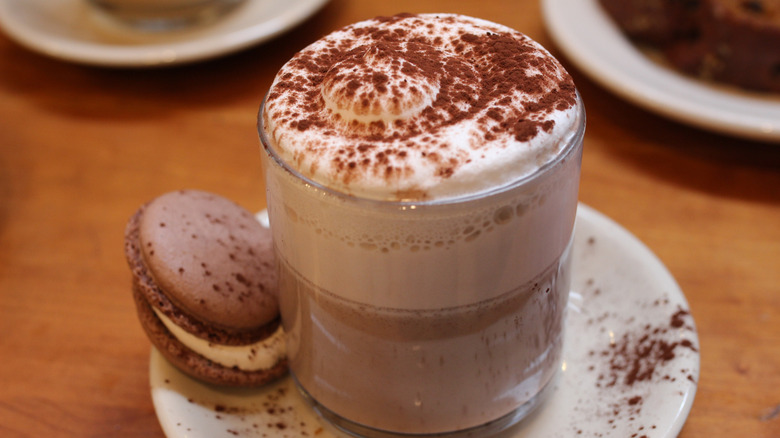 a fancy hot latte with toppings in a glass