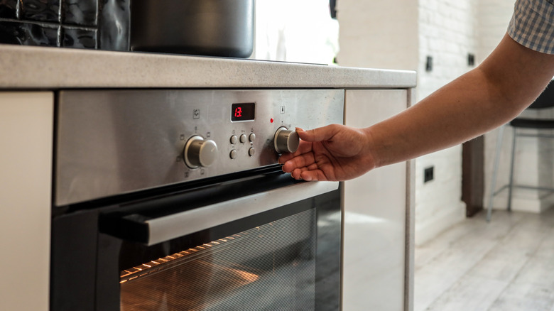 Person adjusting oven dial