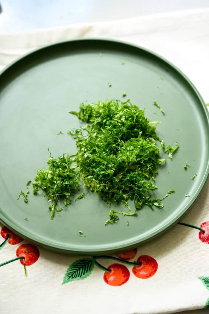 Overhead view of lime zest on a plate.