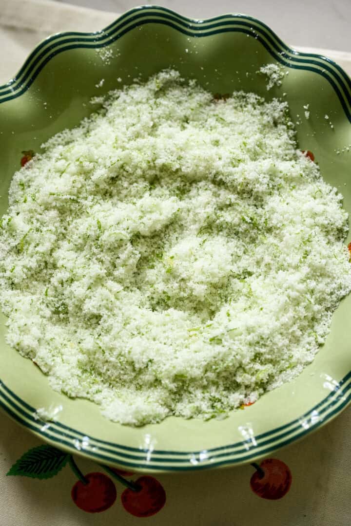 Overhead view of sugar and lime zest after being mixed together.