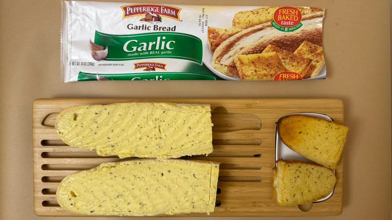 Loaf of Pepperidge Farm Garlic Bread on wooden board beside product packaging