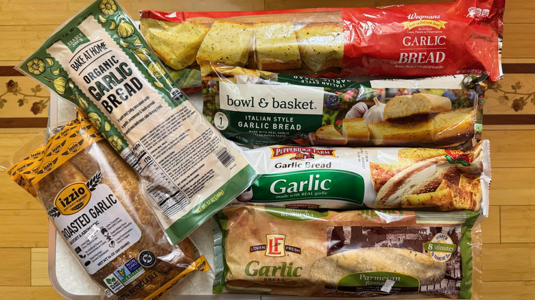 Variety of packaged garlic breads with wooden background
