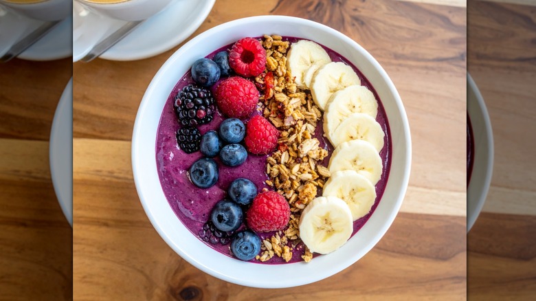 Açaí bowl topped with blueberries, blackberries, raspberries, granola, and banana slices