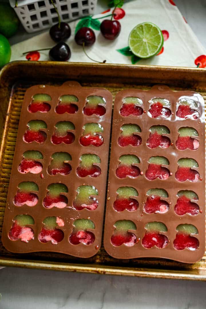 Overhead view of cherry gummies in molds.