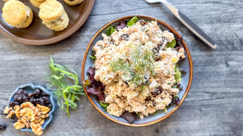 a bowl of Triple Anise Chicken Salad with a sprig of fennel on a gray wooden table