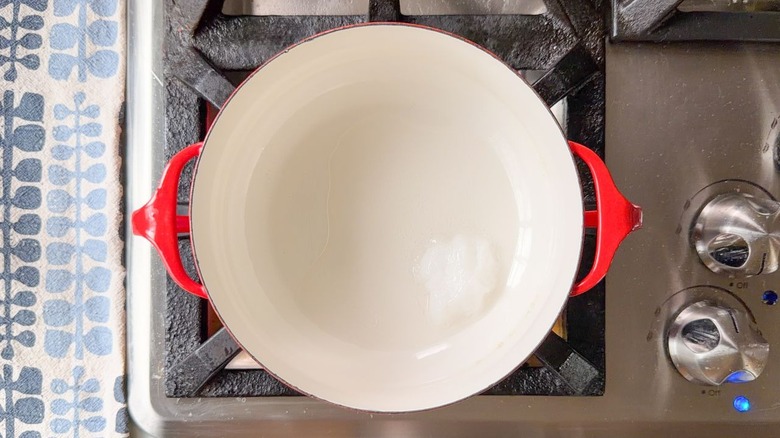 Coconut oil melting in red pot on stovetop