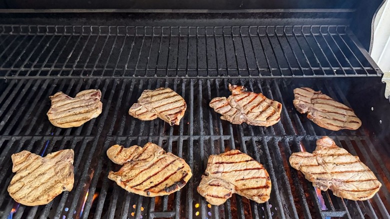 Thin bone-in pork chops on grill