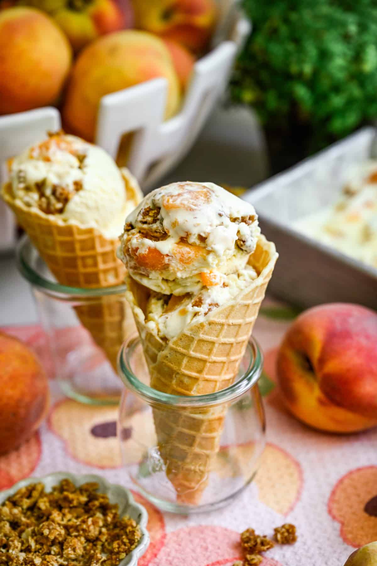 Front view of peach crisp ice cream in ice cream cones.