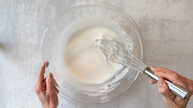 Whisking sesame chicken batter in large glass bowl