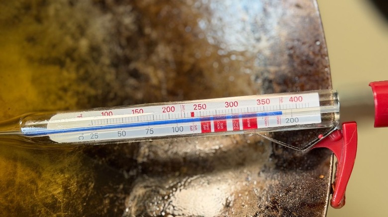 Thermometer reading 375 F in hot oil in wok