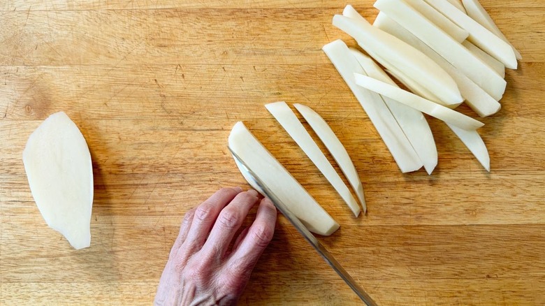 Cutting peeled potatoes into batons