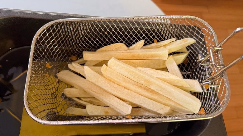 Fryer bubbling with oil and potatoes