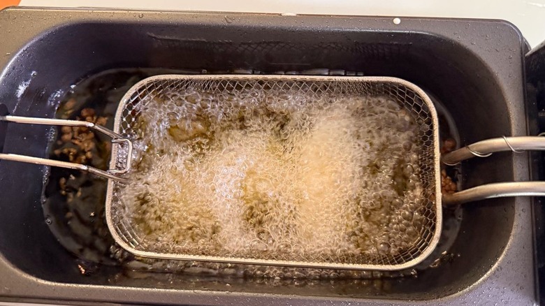 Battered fish filets cooking in hot oil in fryer