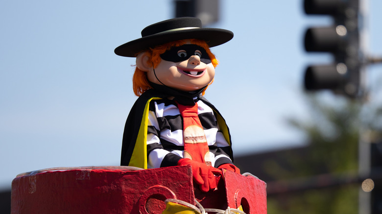 A person dressed in a Hamburglar costume on a parade float