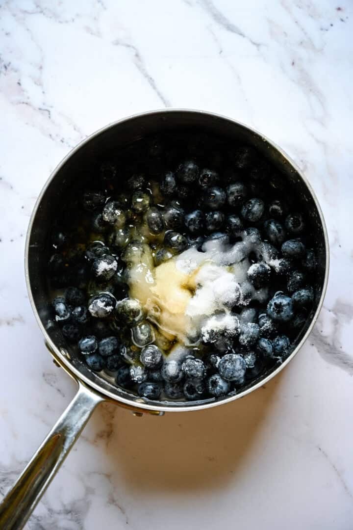 blueberries, sugar, honey and water in a saucepan before cooking.