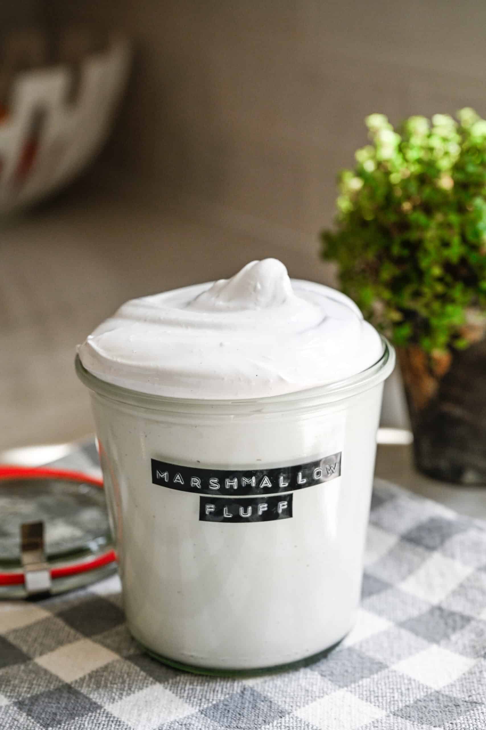 Close up view of homemade marshmallow fluff in a glass jar.