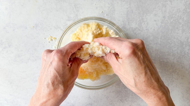 Rubbing orange zest into granulated sugar in small glass bowl