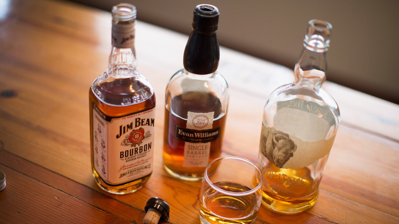 Bourbon bottles on a wooden table.
