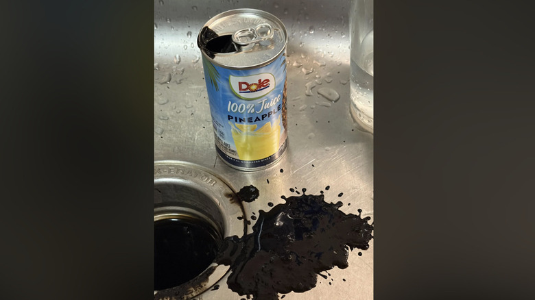the original photo of pineapple juice sitting in the sink with black liquid around it
