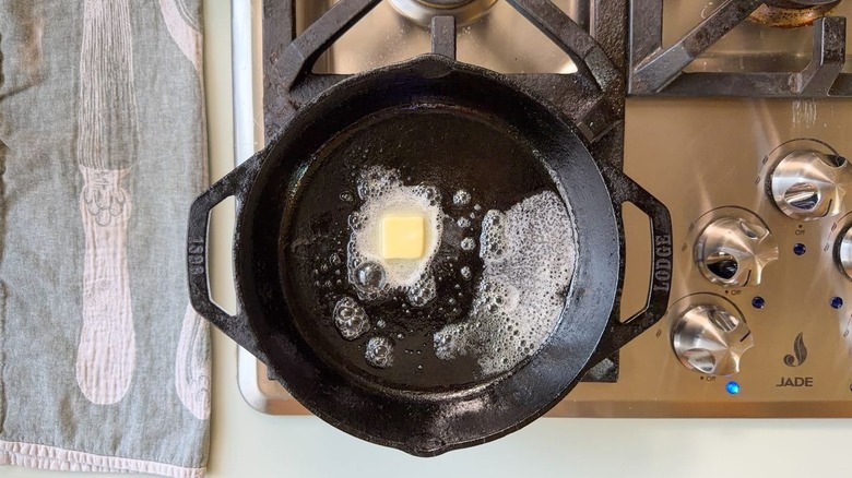 Butter melting in cast iron skillet on stovetop
