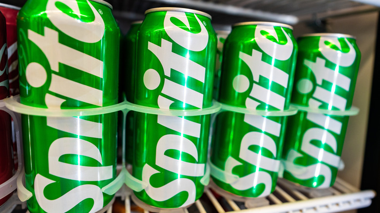Cans of Sprite on a refrigerated store shelf