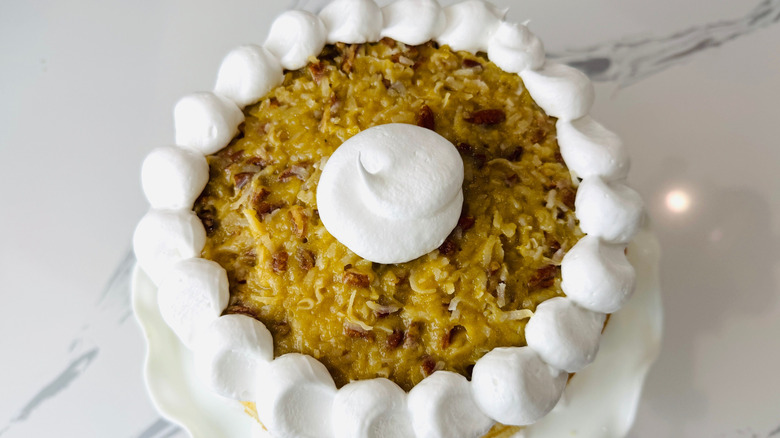Lane cake topped with meringue frosting dollops