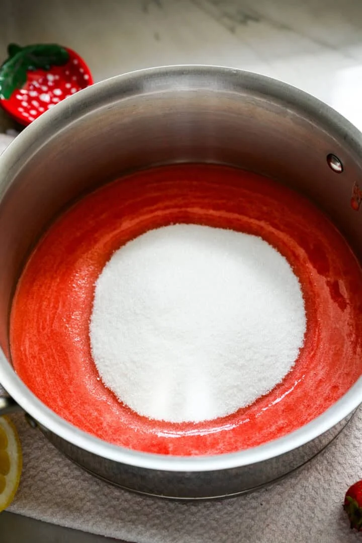 Overhead view of strawberry puree and sugar.