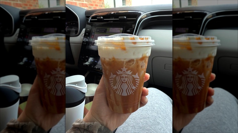 Hand holding vanilla sweet cream cold brew with cold foam