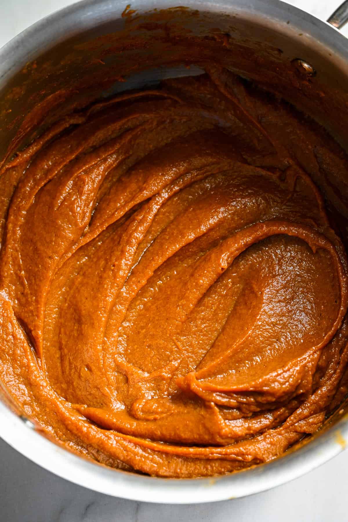 Close up view of homemade pumpkin butter in a saucepan after cooking it down into a thick paste.