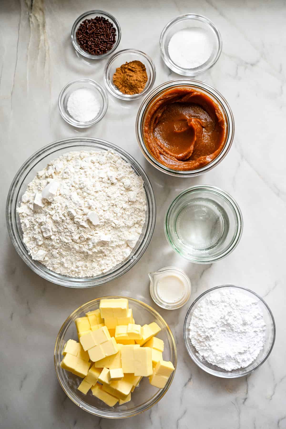 Overhead view of ingredients for pumpkin pie pop tarts in separate bowls. 