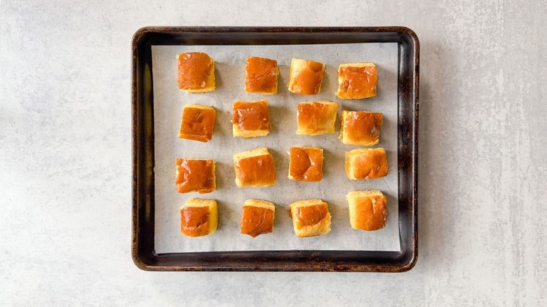 Buttered brioche cubes on parchment-lined baking sheet