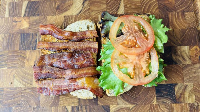 Open faced club sandwich on wooden board