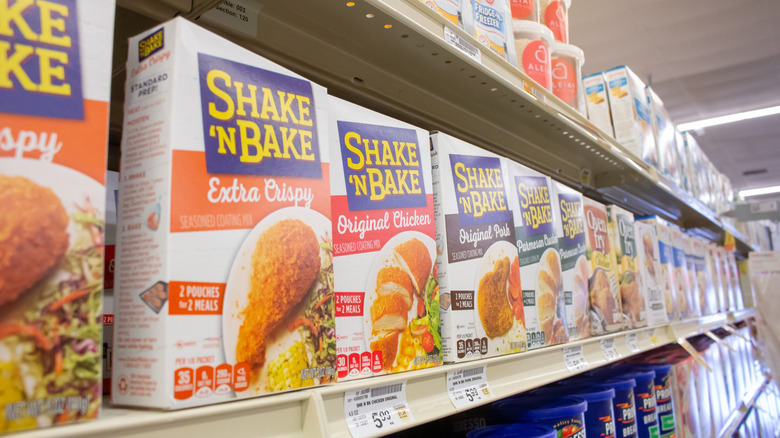 Boxes of Shake 'N Bake lined up on a grocery store shelf.