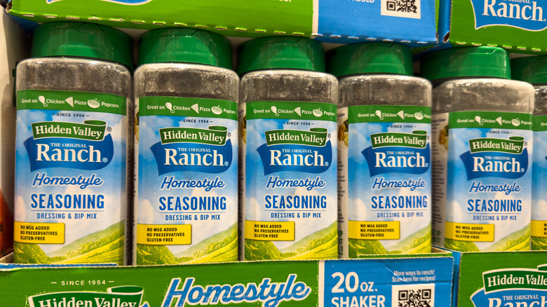 Several containers of ranch seasoning on a store shelf.