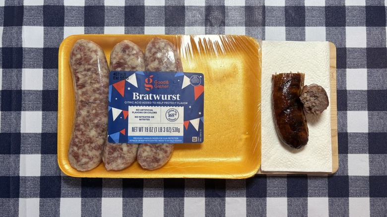 Target Good & Gather brat package next to cooked sausage on checkered tablecloth