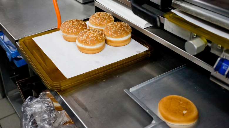 Sesame seed-topped burger buns being prepared at a McDonald's location