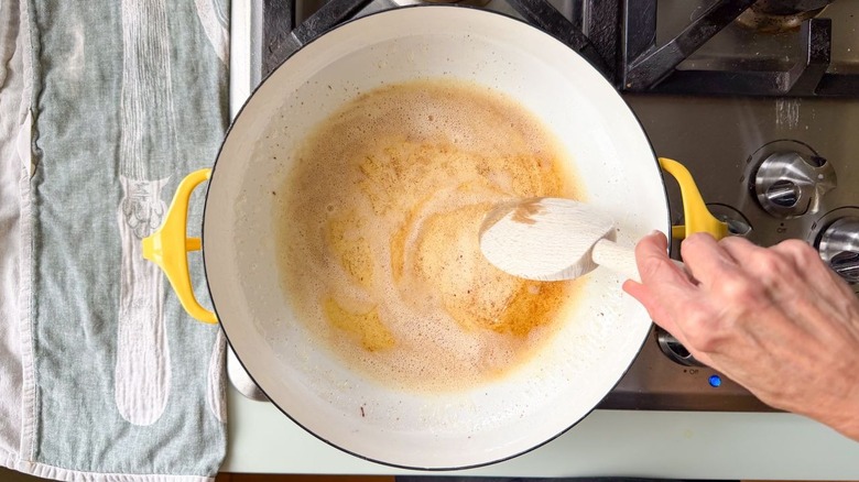 Stirring brown butter in yellow Dutch oven on stovetop