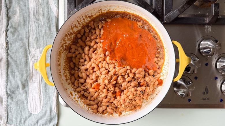 Cooked Mayocoba beans, garlic-chile mixture, and miso brown butter in Dutch oven on stovetop