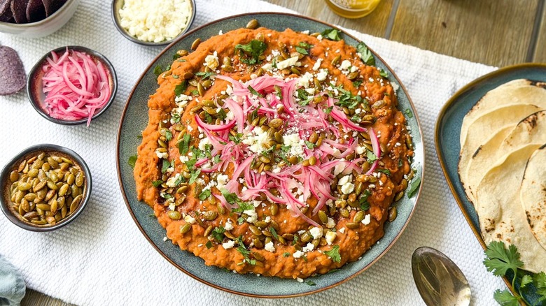 Refried Mayocoba beans on serving platter with garnishes