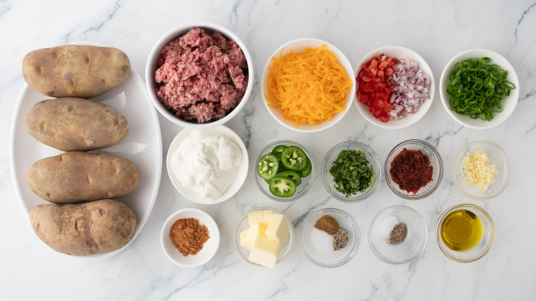 An assortment of ingredients for making taco stuffed twice baked potatoes